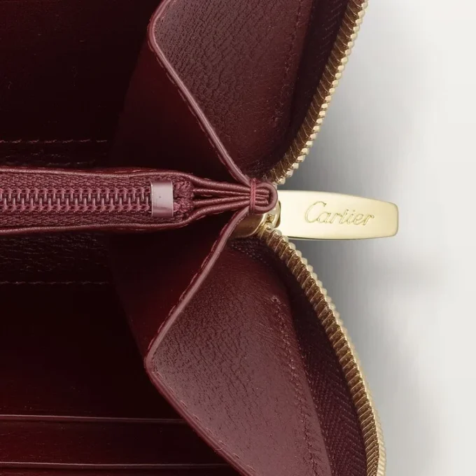 Internasjonal lommebok med glidelås, Must De Cartier – burgunderfarget kalveskinn, gullfinish – Cartier