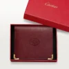 Lommebok med flere lommer, Must De Cartier – burgunderfarget kalveskinn, gullfinish – Cartier